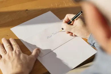 Ältere Person schreibt ihr Testament.