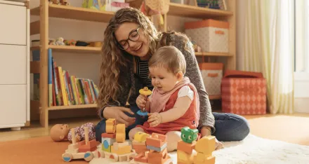 Ein Mädchen beim Spielen mit einem Baby