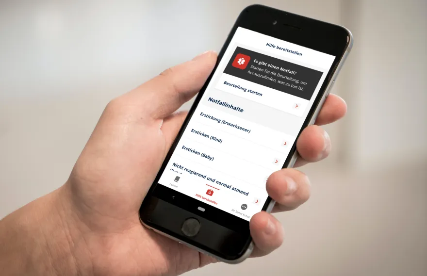Ein Smartphone mit der geöffneten Erste Hilfe App des SRK.